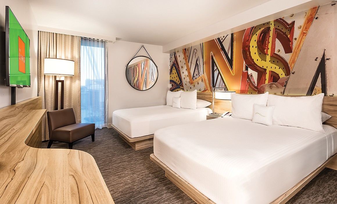 The LINQ Hotel deluxe room with two beds, desk, seating, and mural