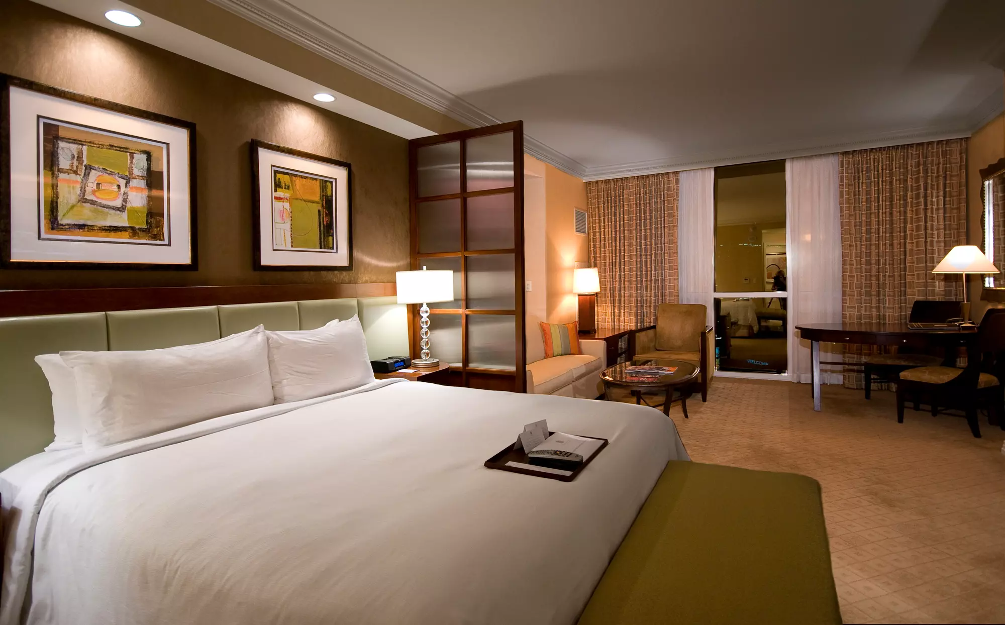MGM Signature hotel bedroom with a large bed dressed in crisp white linens.