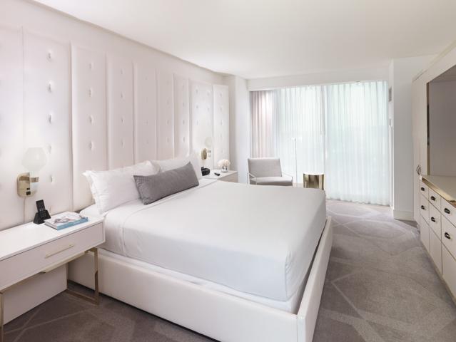 W Las Vegas hotel bedroom with a large bed dressed in crisp white linens.